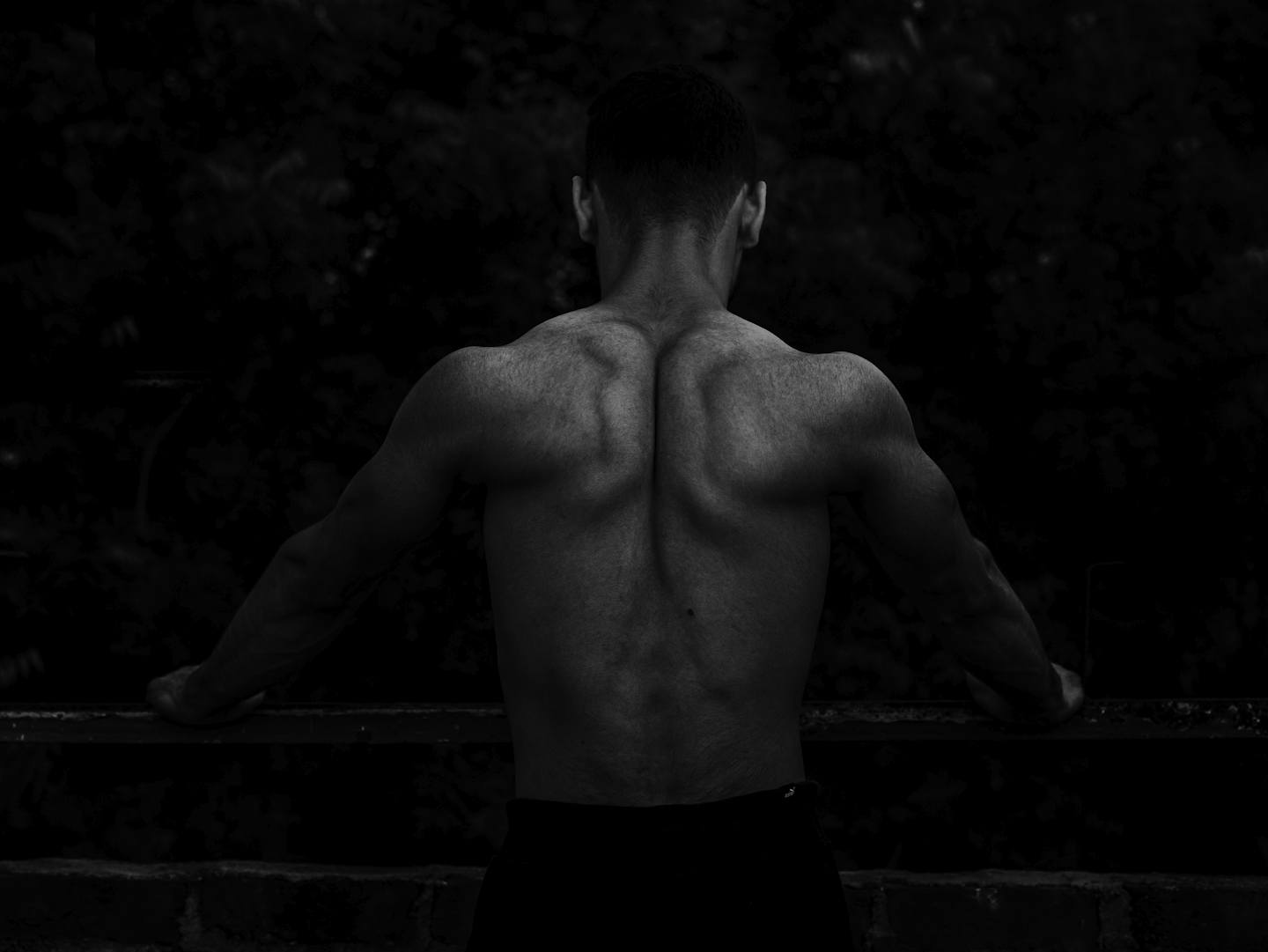 Muscular back of an athlete in low light